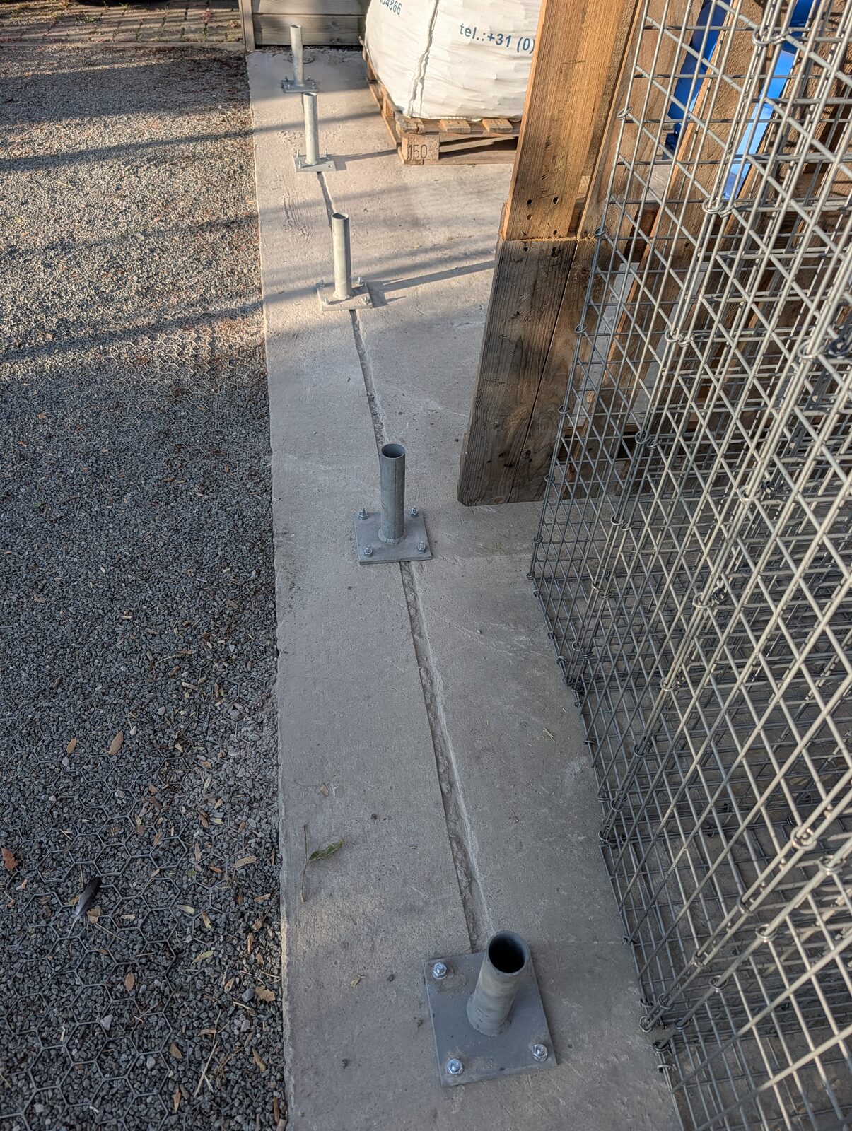 Betonstreifenfundament mit verzinkten Fußplatten für einen hohen Gabionenzaun